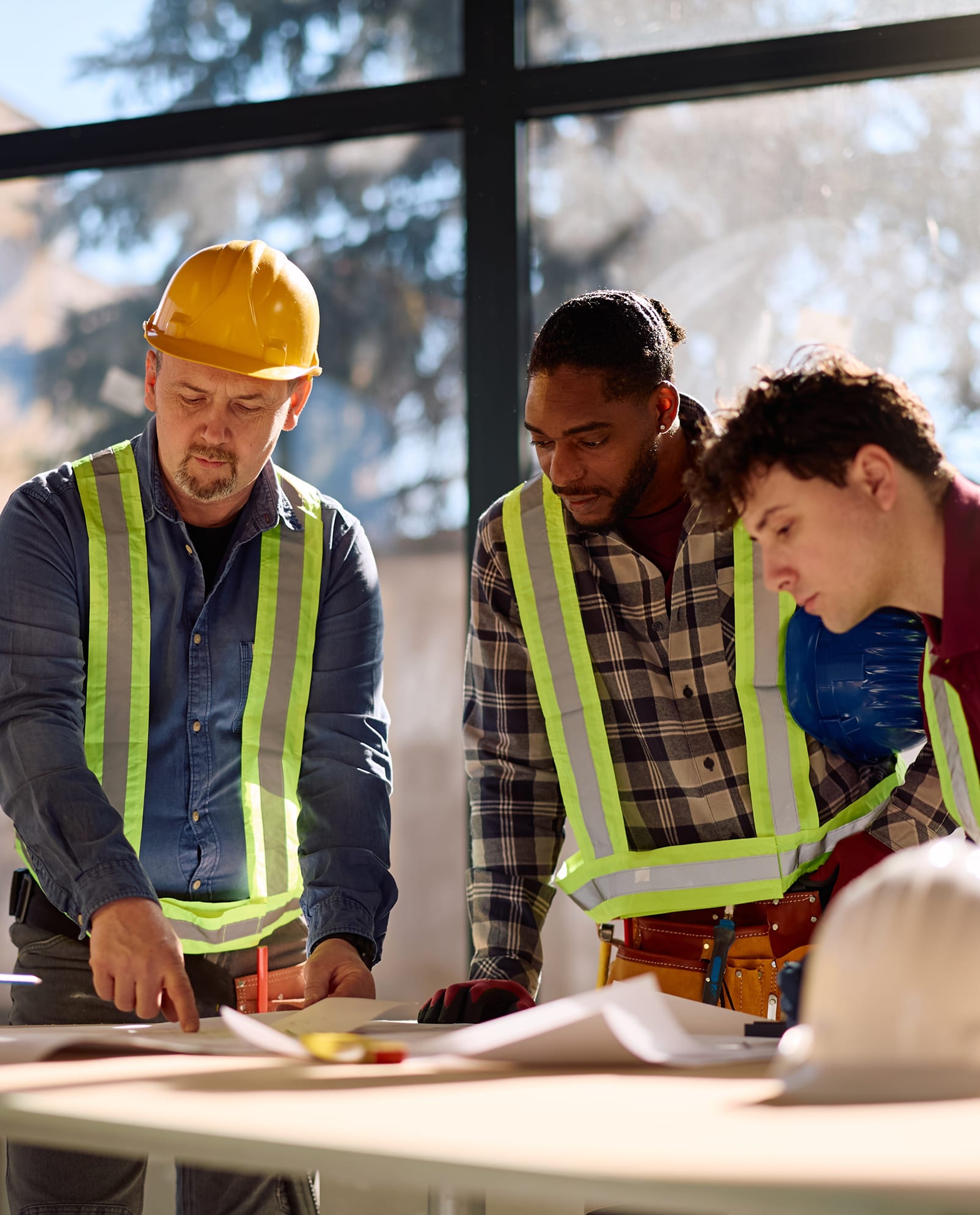 Working professionals collaborating at a table — apartments designed for commuters and busy professionals at Morse Creek