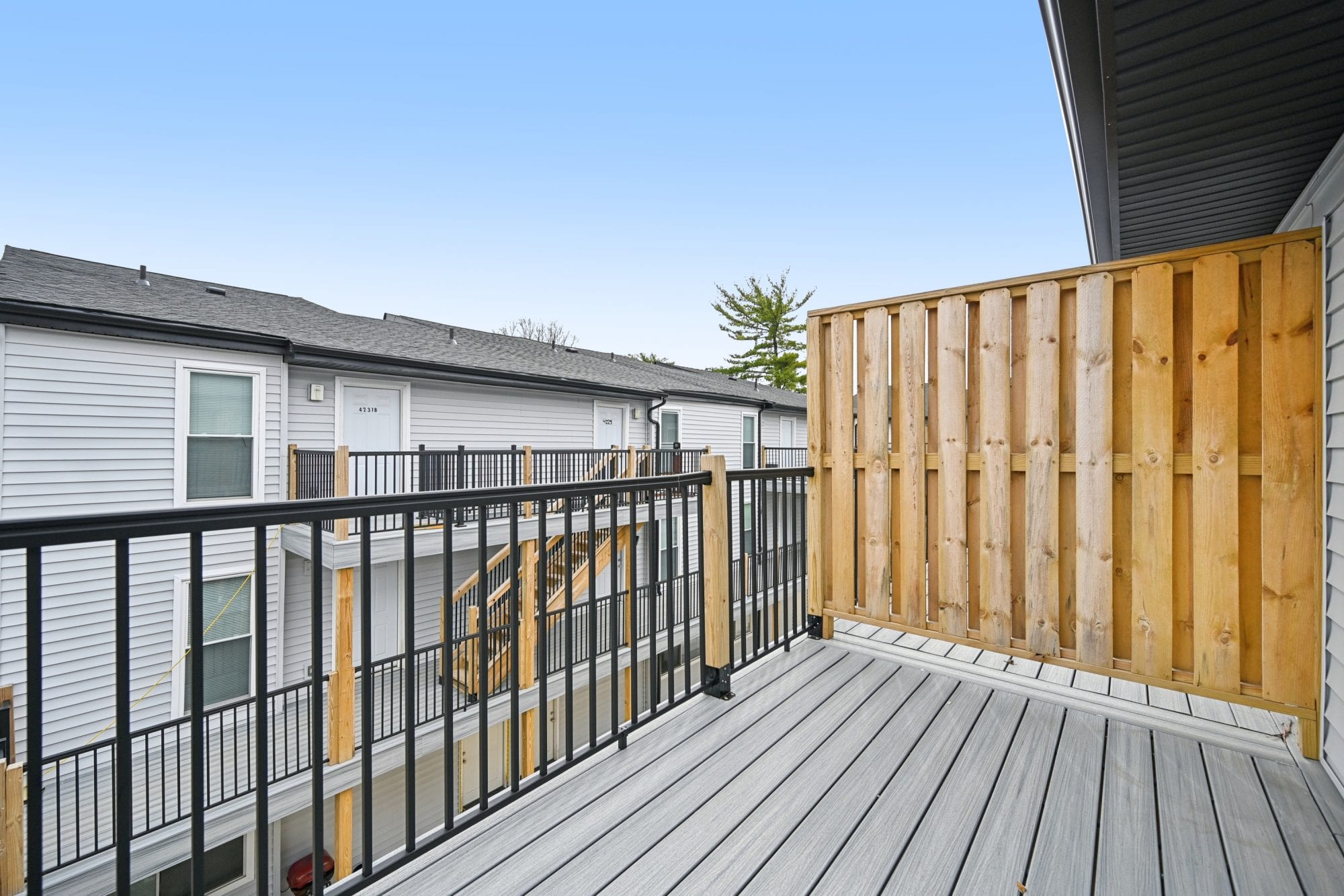 Private apartment balcony with composite decking and a wood privacy screen at Morse Creek Apartments in Columbus, OH